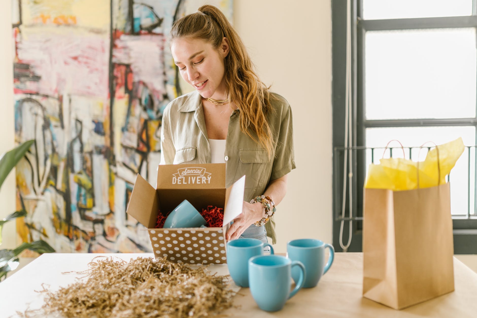 a woman holding a box with a mug